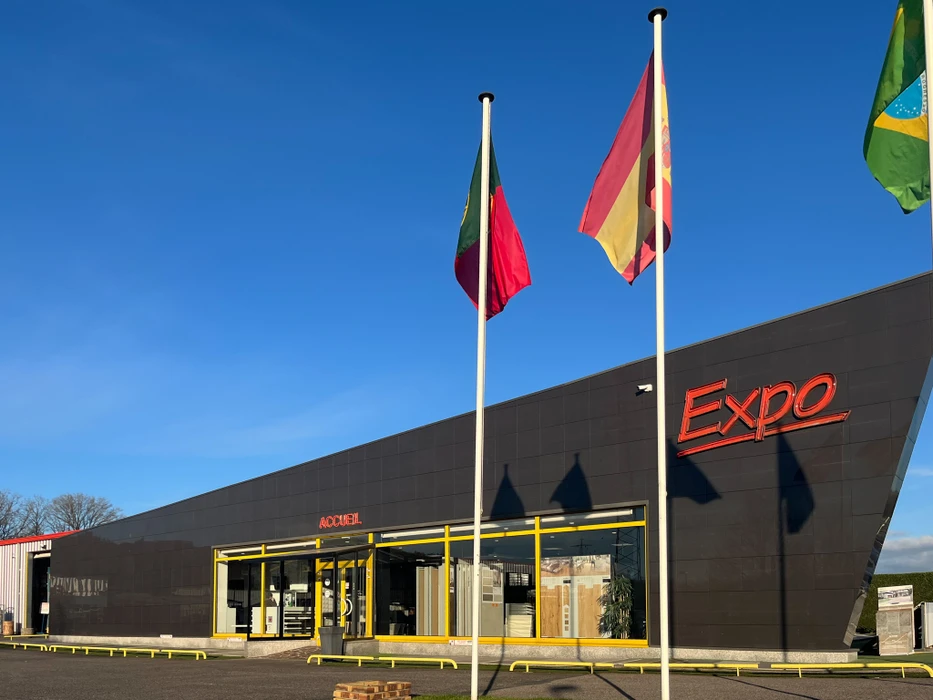 Intérieur atelier artisanal, personne sélectionnant échantillons carreaux céramique dans présentoir bois