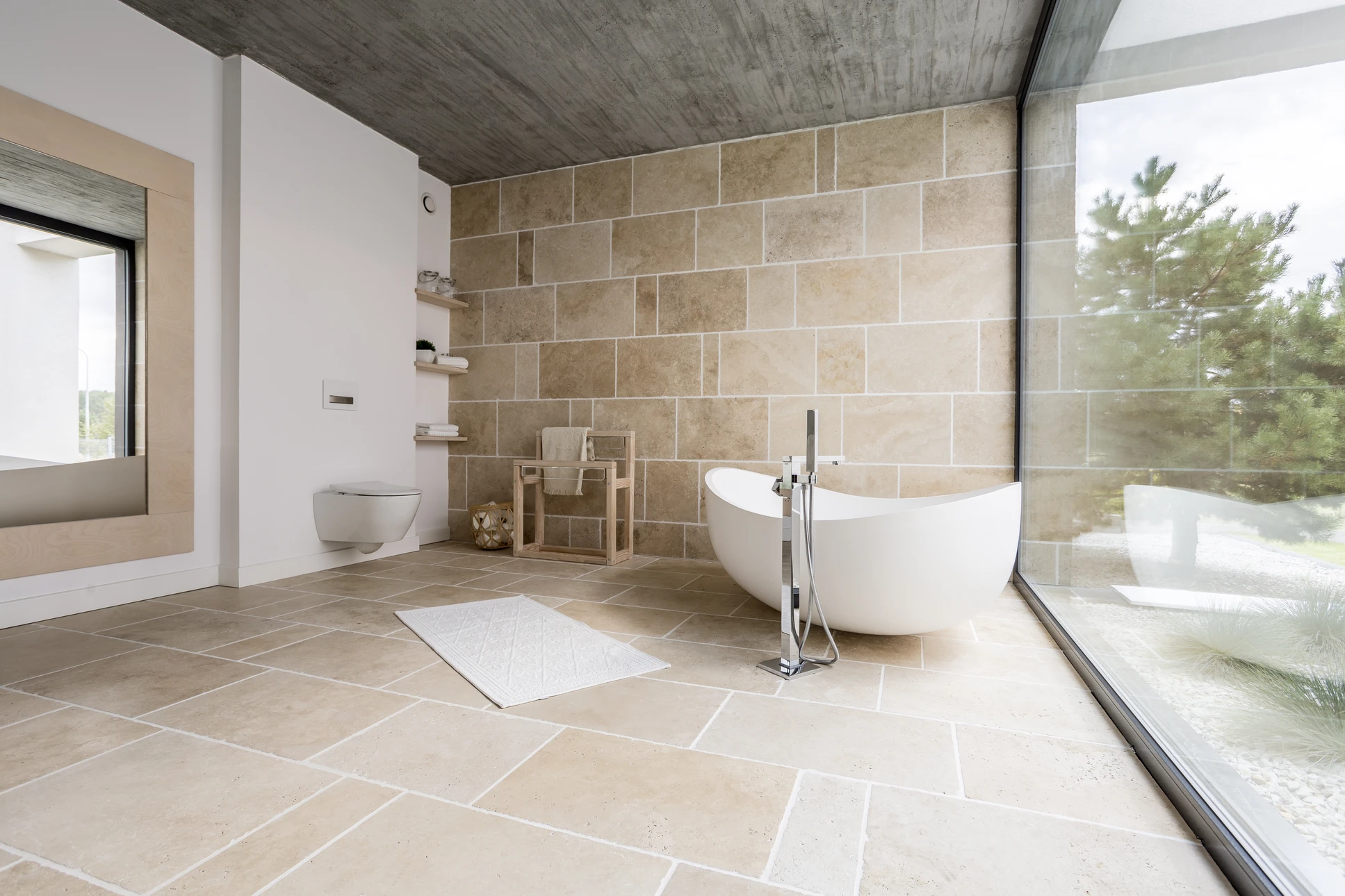 Salle de bain moderne haut de gamme avec baignoire îlot blanche ovale, douche à l'italienne avec paroi vitrée, double vasque sur meuble suspendu anthracite
